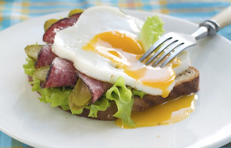 Sandwich with fried egg, sausage and cucumber, selective focus